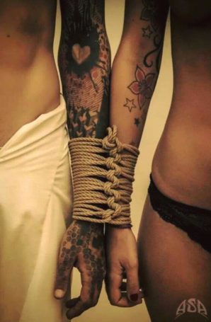 Couple with tatooed arms bound together