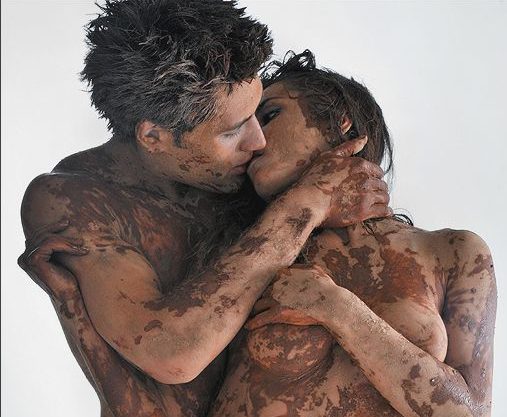Couple kissing with mud on their bodies