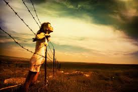 Woman looking over wire fence