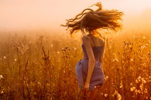 Dancing beautiful girl in fog, field, sun backlight, sunrise, orange colors WILD RADIANCE LIVING LOVE FOR WOMEN