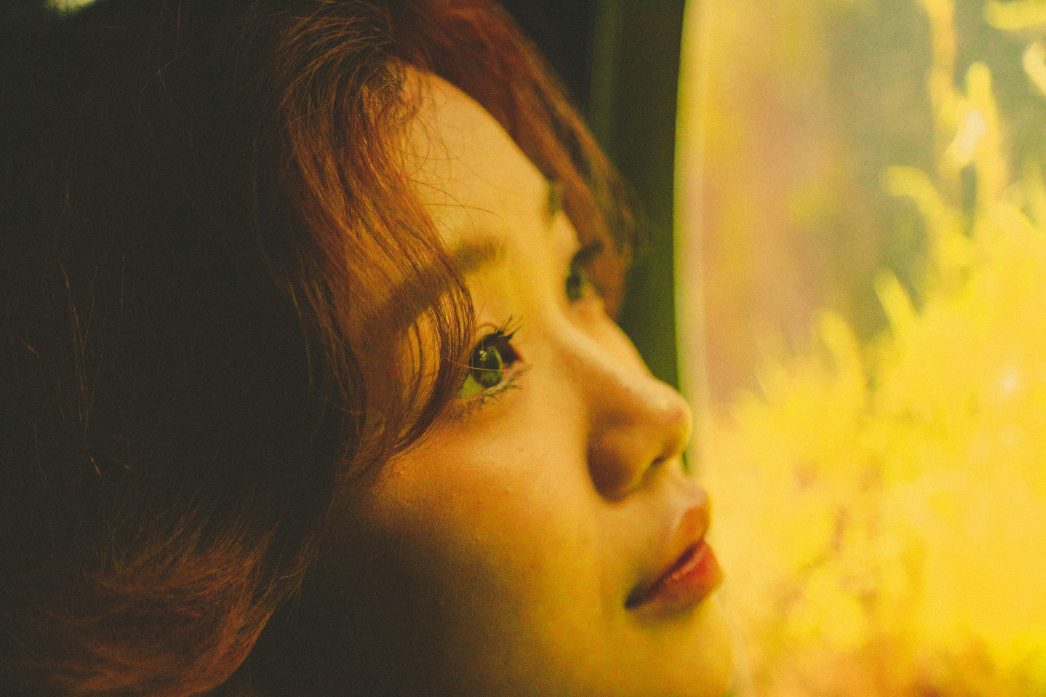 Close up of a woman looking into the distance. Ways to stay positive when single